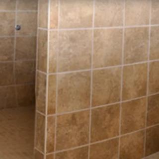 A tiled shower area in a bathroom.
