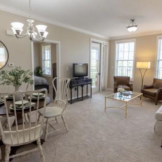 A cozy living room with a dining area, featuring elegant furniture and natural light.