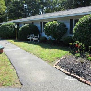 A well-maintained front yard with a pathway and neatly trimmed bushes.
