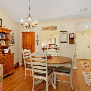A cozy dining room with a wooden table and chairs, featuring a chandelier and warm decor.