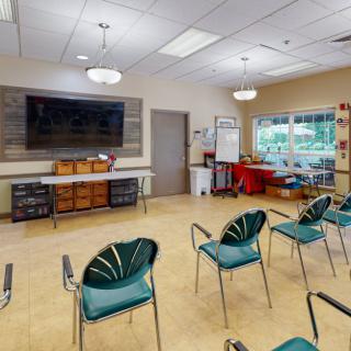 A classroom setting with chairs arranged facing a large television and a whiteboard.