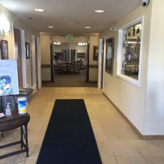 A well-lit hallway leading to another room with doors and decorations.