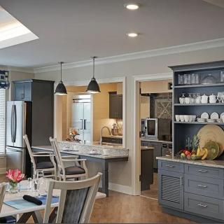 A modern kitchen and dining area with elegant lighting and cabinetry.