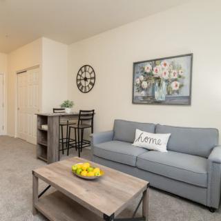 A cozy living room featuring a gray sofa, coffee table with lemon decor, and stylish wall art.