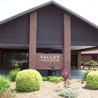 The entrance of the Valley establishment, showcasing modern brick architecture and well-maintained landscaping.