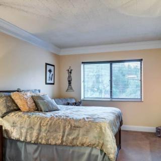 A cozy bedroom interior with a neatly made bed and large window.