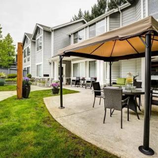 A well-furnished patio area with a canopy and outdoor seating next to a residential building.