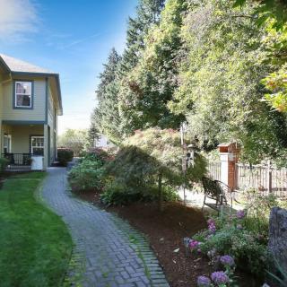 A charming house with a beautifully landscaped garden featuring a winding stone pathway and lush greenery.