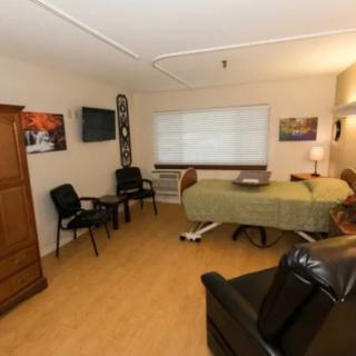 A therapy room with a treatment bed, chairs, and decorative elements.