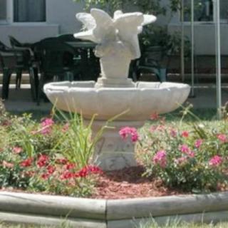 A decorative garden fountain surrounded by vibrant flowers.