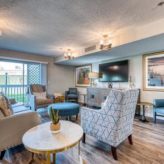 A stylish and modern living room with comfortable seating, a large TV, and contemporary artwork.
