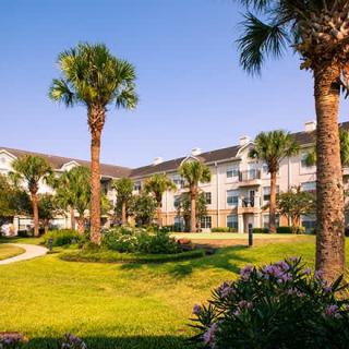 A well-landscaped apartment complex with palm trees on a sunny day.