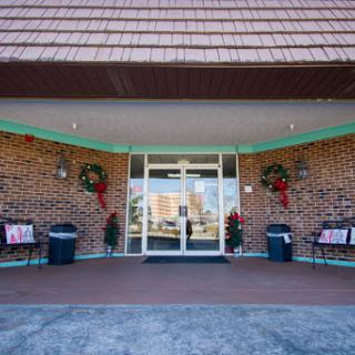 The festive entrance of a building adorned with holiday wreaths and benches.