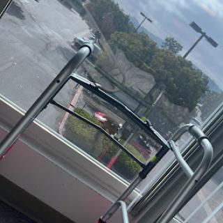 A walker positioned near a window, overlooking a parking lot.