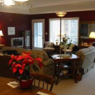 A cozy living room with comfortable seating, a television, and decorative plants.