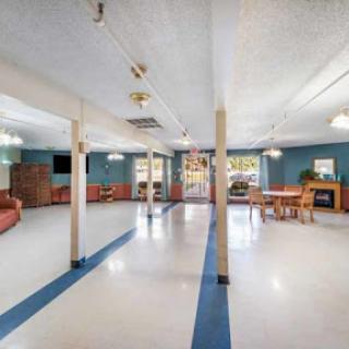 An open community lounge area featuring comfortable seating and bright lighting, suitable for gatherings or activities.