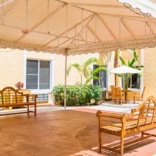 A cozy outdoor patio area with wooden furniture under a canopy, perfect for relaxation.