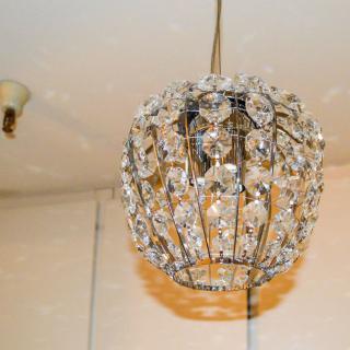 A crystal chandelier hanging from the ceiling, illuminating the interior space with a warm glow.