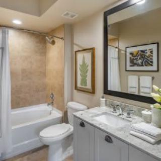 A modern bathroom with a bathtub, sink, and mirror.