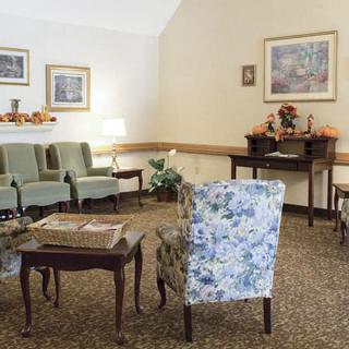 A cozy waiting room with floral-patterned chairs and a warmly decorated interior.