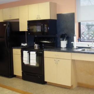 A modern kitchen with black appliances and light-colored cabinets.