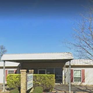 The image shows the entrance to a clinic with a clear blue sky in the background.