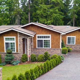 A charming home surrounded by lush greenery and a well-maintained garden.