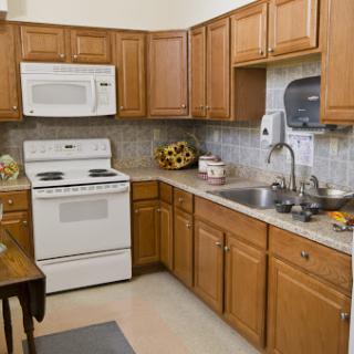 A cozy kitchen featuring wooden cabinets, a stove, and modern appliances.
