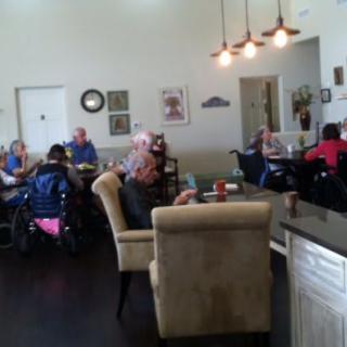Residents gathered in a cozy common area of a nursing home, enjoying social time together.