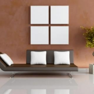 A modern minimalist living room featuring a sleek sofa with white cushions, abstract wall art, and a plant for decor.