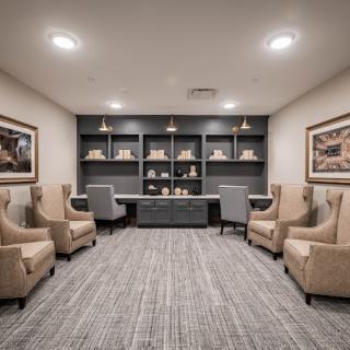 A modern seating area with armchairs, bookshelves, and a desk.