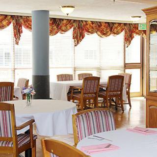 A well-lit dining area with tables and chairs arranged neatly.