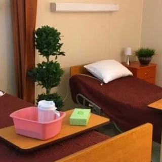 A hospital room with neatly arranged beds and medical supplies.