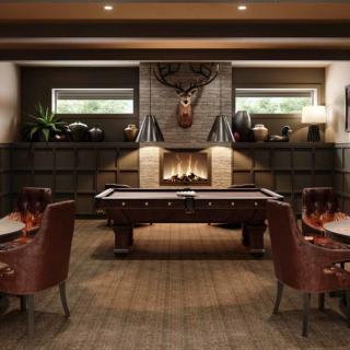 A cozy game room with a pool table and fireplace, featuring leather chairs and a mounted deer head.