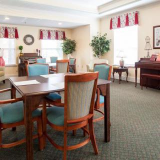 A cozy dining room with elegant furnishings and a piano.