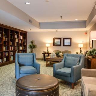 A cozy library area with armchairs and bookshelves, providing a comfortable reading space.