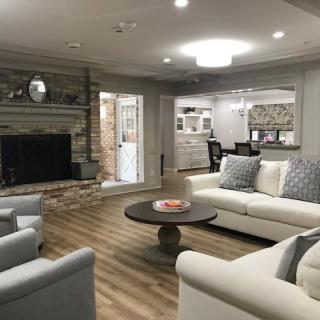 A modern living room featuring comfortable seating, a fireplace, and wood flooring.