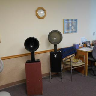 A view of an office space featuring two speakers and a desk with various items.