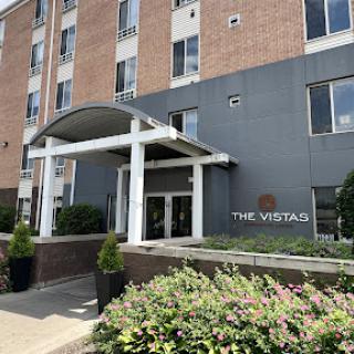 The entrance of The Vista Hotel, showcasing its contemporary design and well-maintained landscaping.