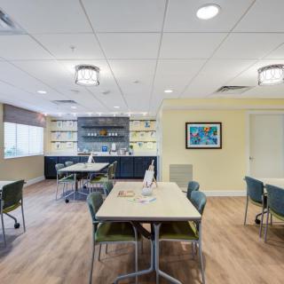 A modern office space featuring tables and chairs, designed for meetings or collaborative work.
