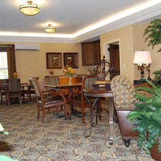 A cozy dining room with elegant furniture and decorative plants.