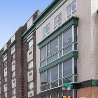 A modern urban building with large windows and a mix of brick and tiled exterior.