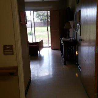 A view of a hospital room with a window overlooking an outdoor area.