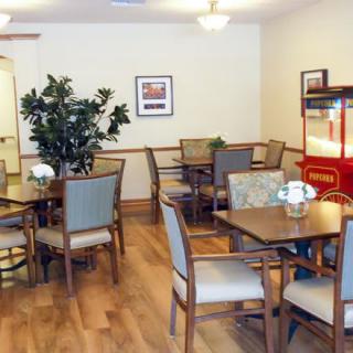 A cozy dining area with tables, chairs, and a popcorn machine.