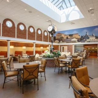 A spacious and elegantly designed dining area featuring comfortable seating and abundant natural light.