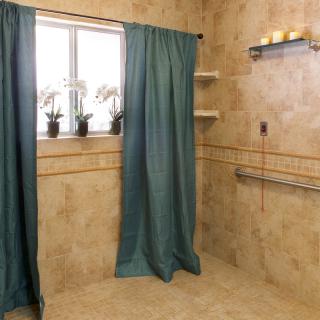 A tiled bathroom with a window, green curtains, and decorative elements like plants and candles.