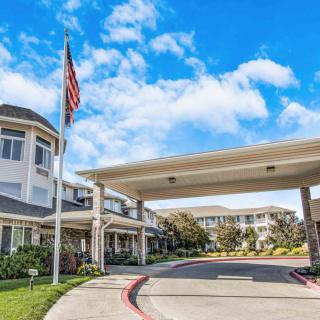 A retirement home with a covered entrance and an American flag on display.