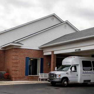 A van parked outside a brick building under a cloudy sky.