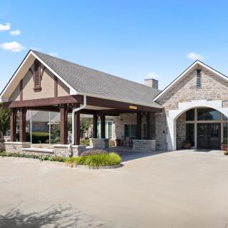 A modern building with a stone facade and a covered entrance.