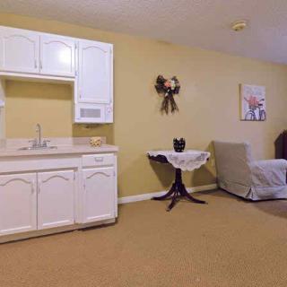 A cozy studio apartment with a small kitchenette and simple furnishings.